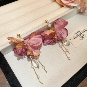 Detail of floral tassel earrings with purple fabric petals and crystal drop pendants
