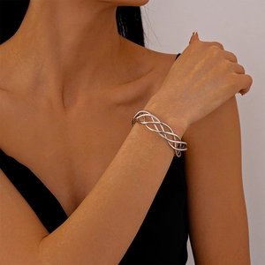 Detail of silver mesh twisted geometric open cuff bracelet on female wrist