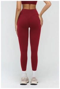 Detail of high-waisted red yoga pants with seamless hip-lifting stitching and elastic fabric