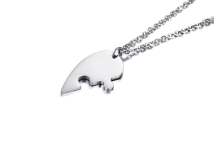 Macro shot of silver titanium steel puzzle piece pendant with polished metal finish
