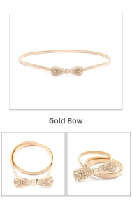 Detailed view of women golden elastic belt with hollow butterfly buckle and leaf accents