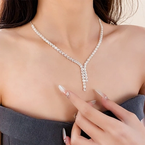 Detailed close-up of a silver Y-shaped zircon tassel necklace on a female model