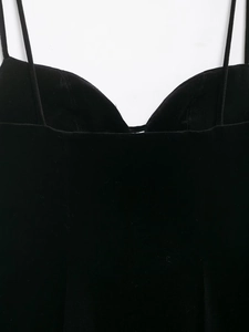 Détail du décolleté en V et des fines bretelles sur la robe courte en velours noir