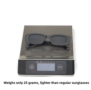 Detailed view of lightweight 25g black rectangular sunglasses on a digital scale