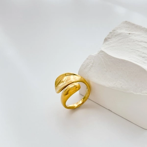 Detail of the fluid gold wrap ring with polished liquid metal texture on white stone