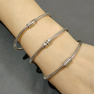 Three silver stainless steel snake chain bracelets with magnetic clasps on a wrist