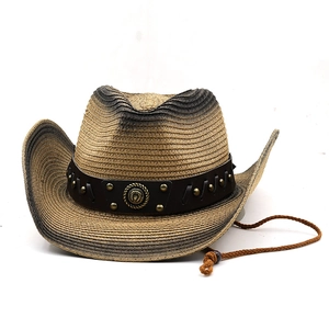 Close-up of rivet leather belt and horseshoe metal buckle on gradient straw cowboy hat