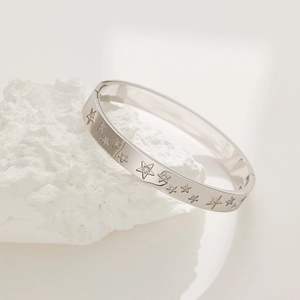 Elegant silver star-shaped bracelet in stainless steel with zircon stones on white stone
