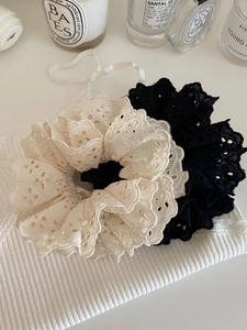 Détail de chouchous élégants en dentelle brodée noire et blanche dans un décor chic