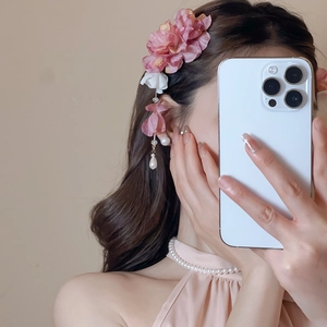 Détail d'une pince à cheveux en fleurs de soie rose avec glands en perles et chaîne