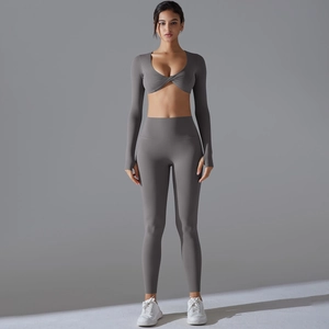Detail eines Yoga-Oberteils mit überkreuztem Ausschnitt und hoch taillierten Leggings in Grau