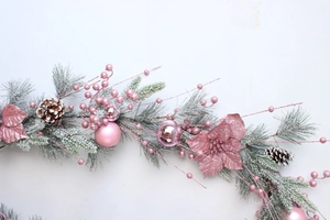 Detailed close-up of pink Christmas wreath with flocked pine needles and ornaments