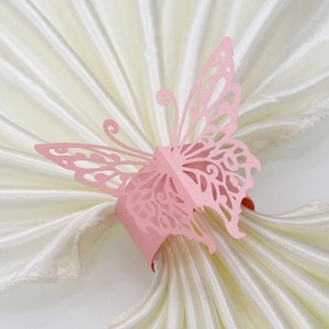 Detailed laser-cut pink butterfly napkin ring on white satin fabric for table decor