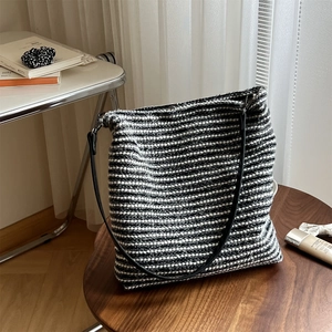 Détail du sac cabas en tricot rayé noir et blanc avec texture et fines bandoulières