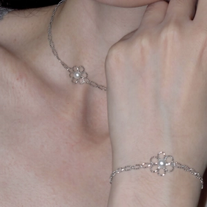 Elegantes Set aus silberner Halskette und Armband mit hohlen Blumen und Perlen