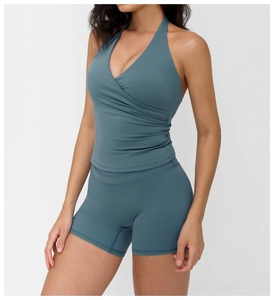 Detail view of V-neck halter yoga top with cross-pleated waist and matching shorts