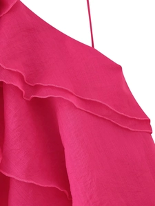 Macro detail of rose pink layered ruffles and textured fabric on the mini dress