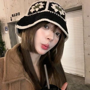 Detailed macro view of retro floral crochet pattern on black knit bucket hat for women