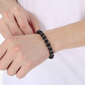 Close-up of black lava stone beaded bracelet with silver spacers on a model wrist
