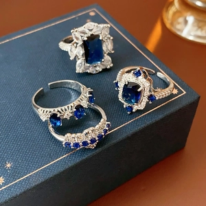 Macro de parure de 4 bagues argentées avec saphir bleu rectangulaire et zircons brillants