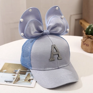 Detail of child sun hat with breathable mesh fabric and large pearl bow decoration