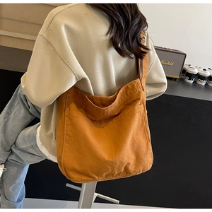 Close-up of large canvas tote bag with wide shoulder straps in vintage orange brown