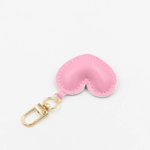 Close-up of pink PU leather heart-shaped keychain with white stitching and gold lobster clasp