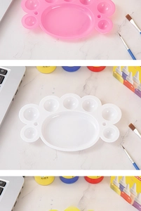 Macro detail of paw-shaped painting palette with eight mixing zones in pink and white