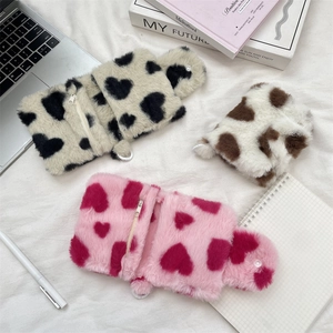 Close-up of plush heart storage pouches showing metal zippers and soft texture details