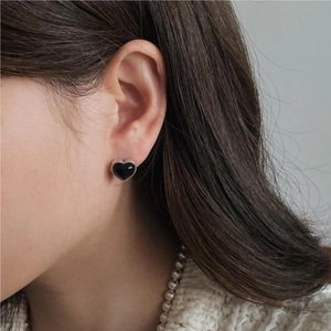 Detailed close-up of a 925 silver heart earring with black agate on a model's ear