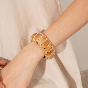 Detail of vintage resin and gold-plated metal geometric elastic bracelet on wrist