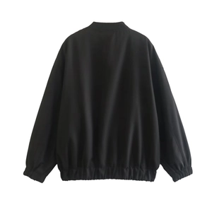 Détail du col montant et des poignets élastiques sur une veste noire oversize