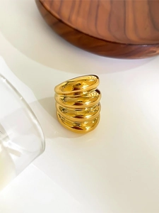 Macro detail of glossy gold layered rings with polished fluid metallic texture