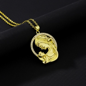 Macro detail of gold-plated mother and child cameo pendant with white zircon stones