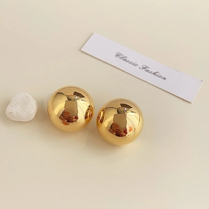Detail of 18K gold-plated spherical stud earrings with high-polish mirror finish