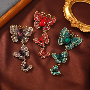 Vintage gold butterfly brooches with colorful rhinestones on elegant silk background