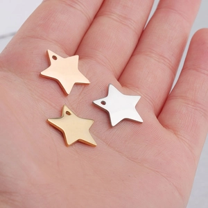 Star-shaped stainless steel charms in gold, silver, and rose gold held on palm