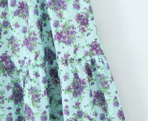 Detailed macro view of light blue floral fabric with pleated texture and purple print