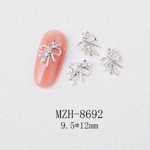 Macro shot of 9.5x12mm silver bow nail art charms with iridescent AB rhinestones