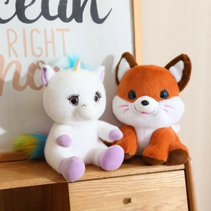 Close-up of fluffy plush toys including a white unicorn and an orange fox doll