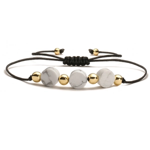 Detail of adjustable handmade woven bracelet with marble beads and gold metallic accents