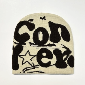 Close-up of beige knit beanie featuring black CON jacquard pattern and star embroidery