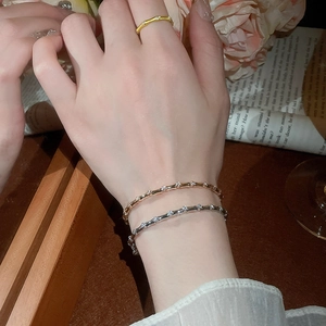 Detail shot of stacked gold bamboo joint bangles with sparkling zircon accents