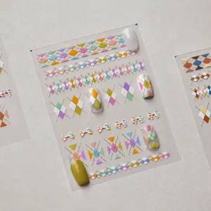 Close-up of colorful argyle pattern and bow nail stickers for creative manicure designs