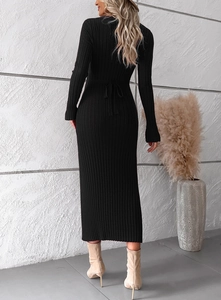 Vue arrière d'une robe noire en maille côtelée avec ceinture sur mur béton