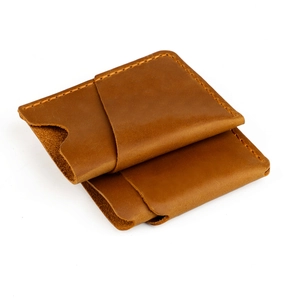 Detail of vintage brown crazy horse leather card holder with manual yellow stitching