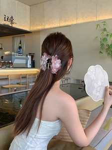 Dettaglio del fermaglio per capelli con fiori in tulle rosa e perle eleganti