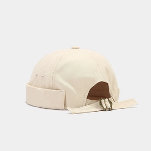 Détail du bonnet docker en toile beige avec boucle métallique réglable et œillets