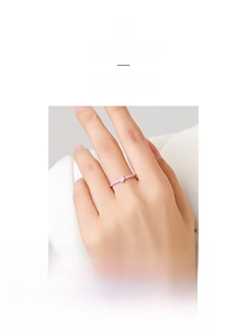 Detail of pink enamel silver ring with heart-shaped stone worn on a finger