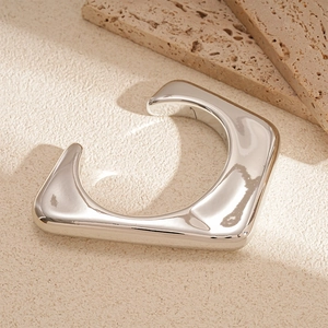 Macro shot of silver irregular geometric open bangle with polished mirror finish